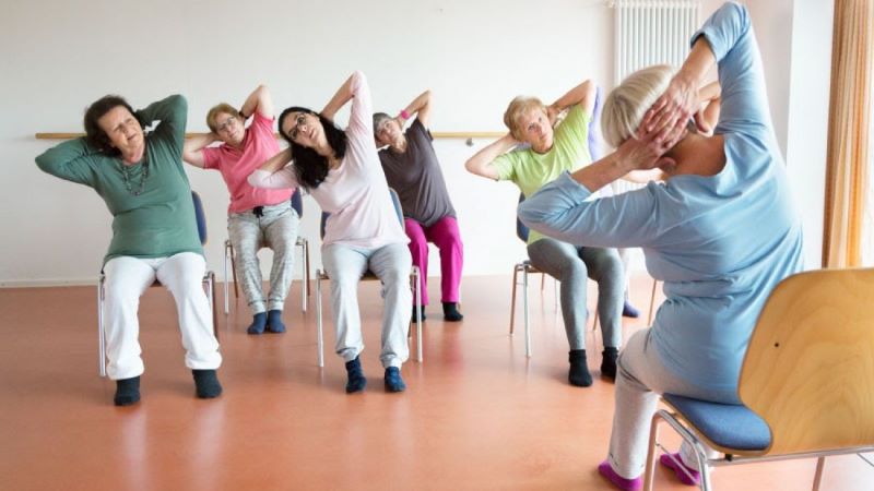 Group exercising while sitting in chairs