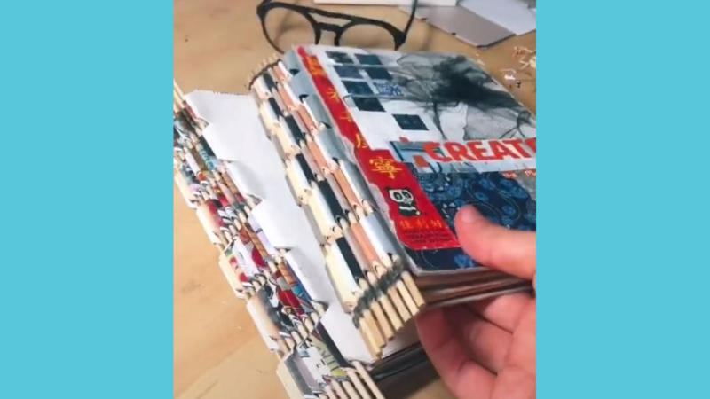 DIY sketchbook with recycled magazines and wooden dowels.