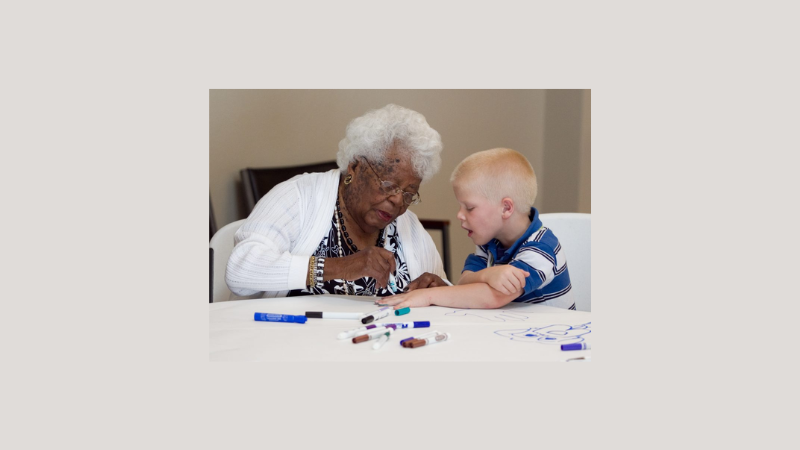 Elderly woman playing a tabletop game with a young boy.