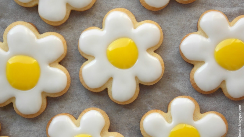 Sugar cookies shaped and decorated to look like white daisies.
